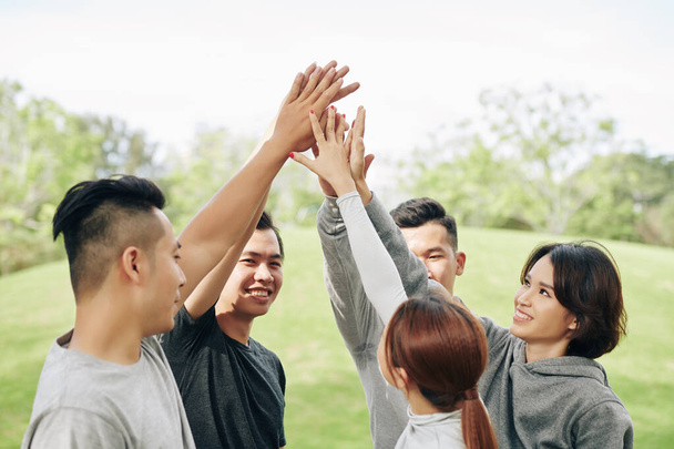 jeunes Asiatiques joyeux se donnant cinq après avoir terminé la formation en plein air - Photo, image