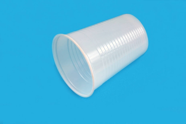 Taza de plástico de primer plano sobre fondo azul  - Foto, imagen