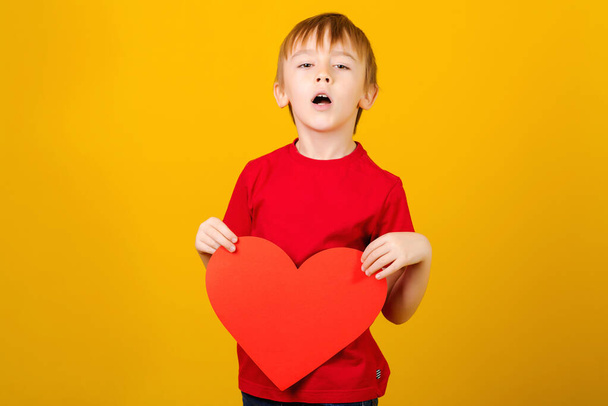 Kid holding red heart. Concept of love, charity and social donatation. Cute child with red paper heart. - Fotografie, Obrázek