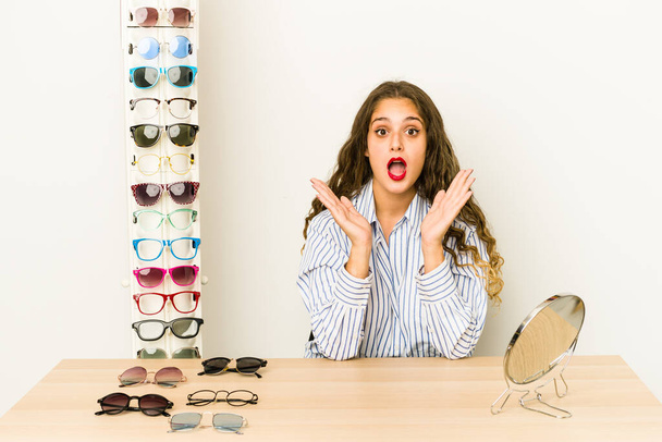 Junge kaukasische Frau versucht Brille isoliert überrascht und schockiert. - Foto, Bild