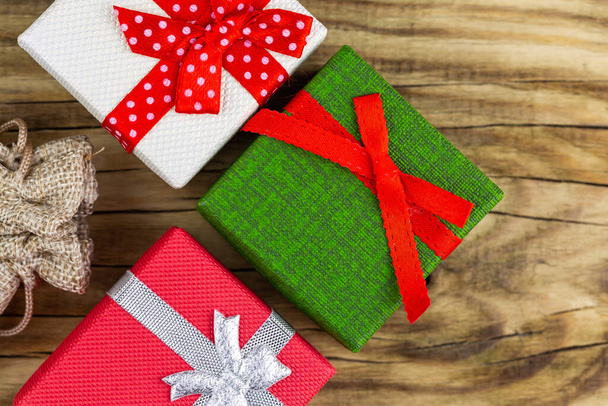 Colorful gift boxes stacked on a wooden background - Fotografie, Obrázek