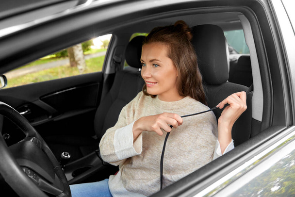 woman or female driver fastening seat belt in car - Fotoğraf, Görsel