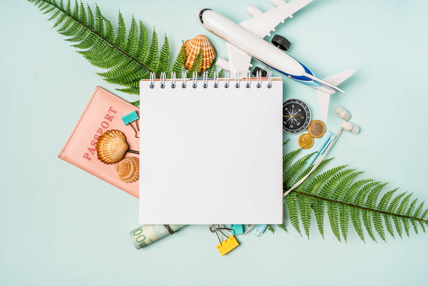 An open notebook with space for text and travel accessories on a blue pastel background. Planning your summer vacation, travel, and vacation. A set for a blogger, a traveler. - Photo, Image