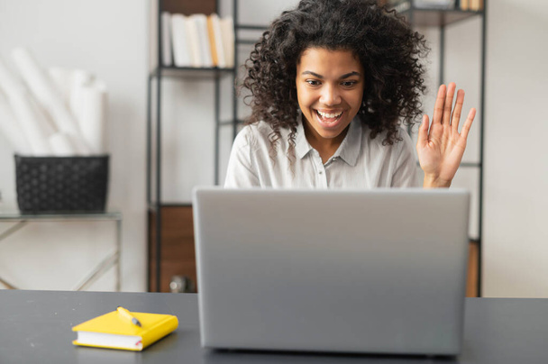 African American woman waving at the laptop screen - Foto, Imagen