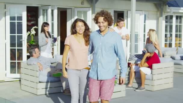 Couple socializing with friends outside beachside home - Video, Çekim