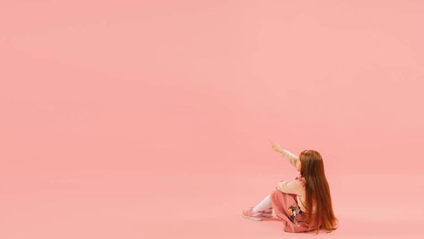 Childhood and dream about big and famous future. Pretty longhair girl isolated on coral pink background - Foto, Imagem
