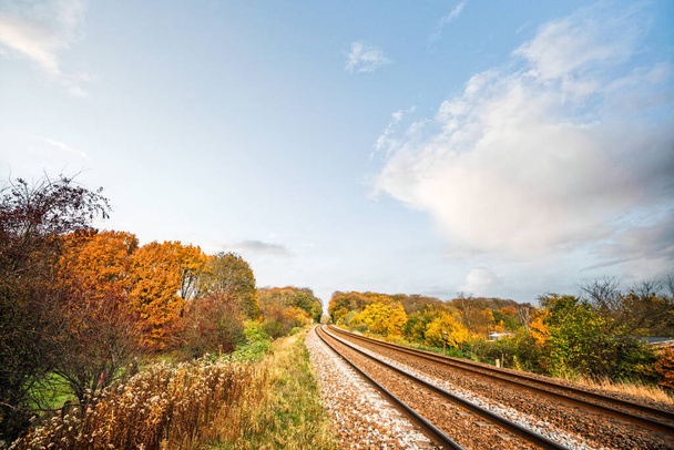 Железнодорожные трассы осенью в яркий день на красочных окрестностях осенью - Фото, изображение