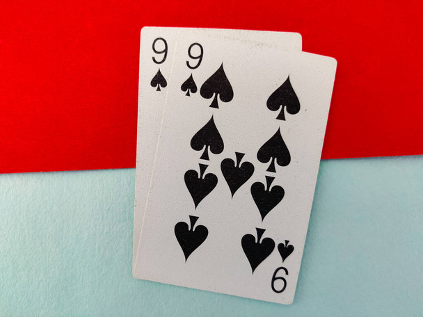 Yhdeksän pata pelaa korttia kaksi numeroa eristetty punainen ja vihreä tausta. 99 artikla - Valokuva, kuva
