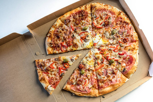 Pizza dans une boîte en carton de livraison sur fond blanc. Vue d'en haut. Livraison de pizza - Menu pizza - Photo, image