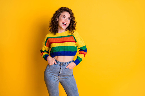 Photo portrait of laughing girl with two hands in pockets isolated on vivid yellow colored background - Fotografie, Obrázek