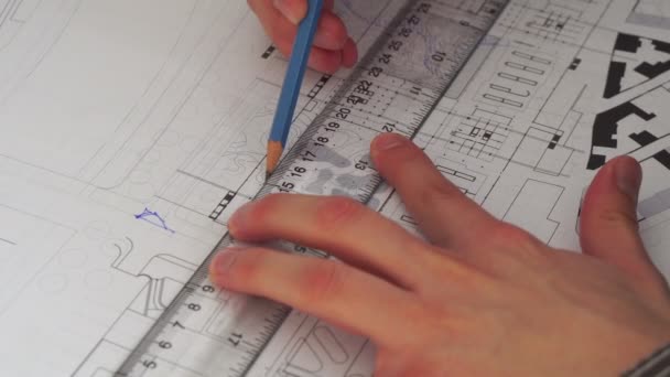 Gros plan de l'ingénieur en design masculin assis au bureau, les plans posés sur son bureau - Séquence, vidéo