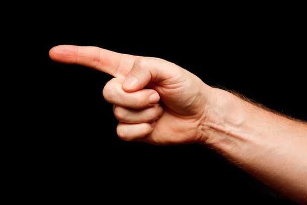 Käsi ja sormi osoittavat jotain mustalla taustalla - Valokuva, kuva
