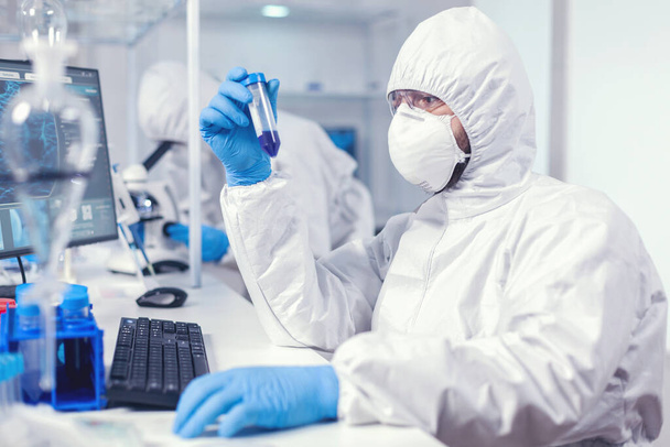 Γιατρός που διεξάγει επιστημονική έρευνα για ιούς κρατώντας δοκιμαστικό σωλήνα - Φωτογραφία, εικόνα