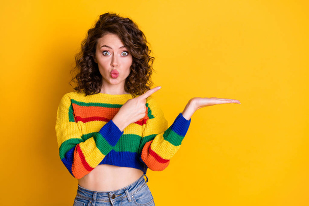 Photo of pretty funny girl indicate forefinger arm hold empty lips wear striped pullover isolated yellow color background - Foto, Bild