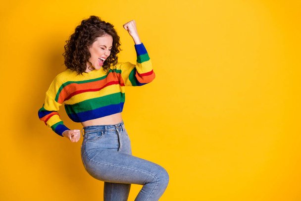 Profile photo of amazed careless lady raise arm scream wear striped pullover denim jeans isolated vibrant yellow color background - Foto, Imagem