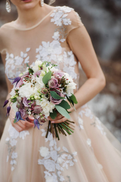 wedding bouquet with peonies in the hands of the bride under the veil.Morning of the bride. - Foto, Bild