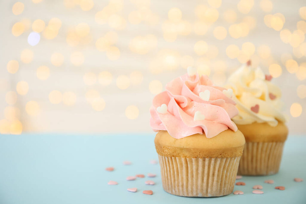 Tasty cupcakes on table against blurred lights, space for text. Valentine's Day celebration - Photo, image