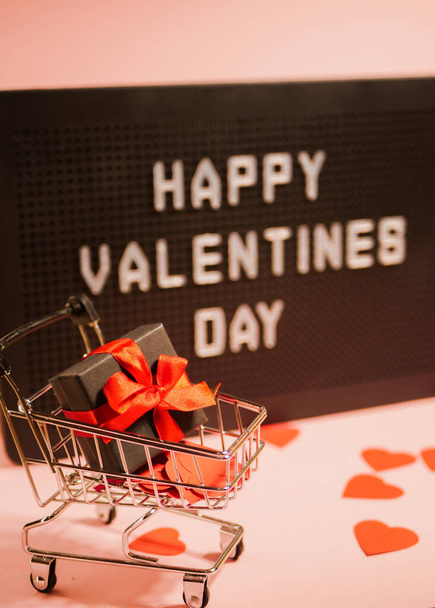 Valentinstag-Verkauf. Einkaufskarte mit Geschenkbox. Hintergrund der Meldung. Online-Shopping. Vertikale Orientierung  - Foto, Bild