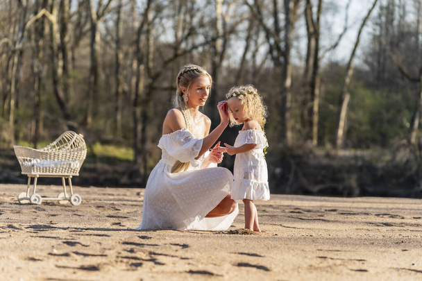 A beautiful young mother and her daughter enjoy the spring weather - Photo, Image
