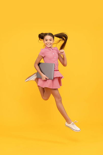 веселая девочка-подросток бегать с компьютером для изучения в Интернете, образование. - Фото, изображение