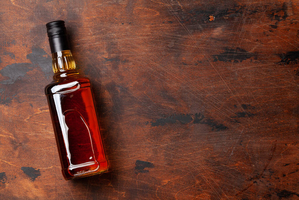 Scotch μπουκάλι ουίσκι σε ξύλινο τραπέζι. Με χώρο αντιγραφής. Πάνω όψη επίπεδη lay - Φωτογραφία, εικόνα