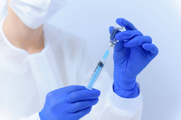 De arts vult de spuit met medicijnen, close-up. Vaccinatie en immunisatie - Foto, afbeelding