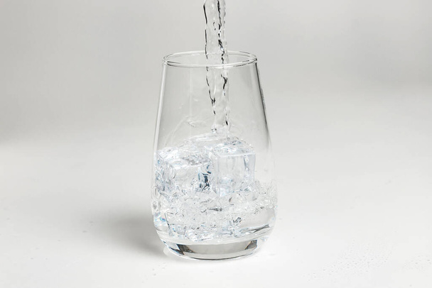 clean water is poured into a glass cup. ice in a glass. - Valokuva, kuva