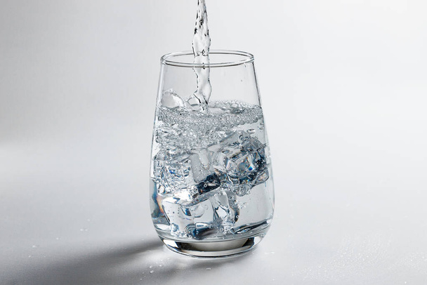 clean water is poured into a glass cup. - Zdjęcie, obraz