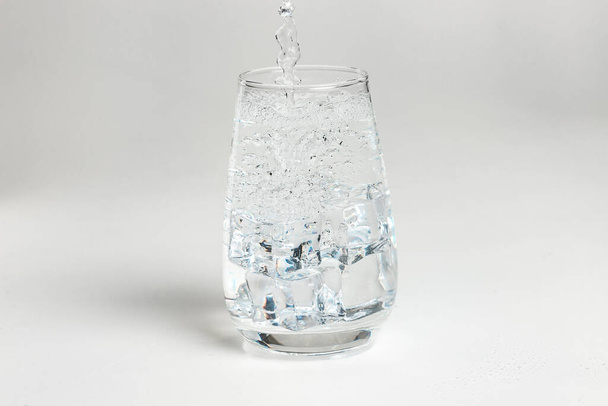 clean water is poured into a glass cup. - Foto, immagini