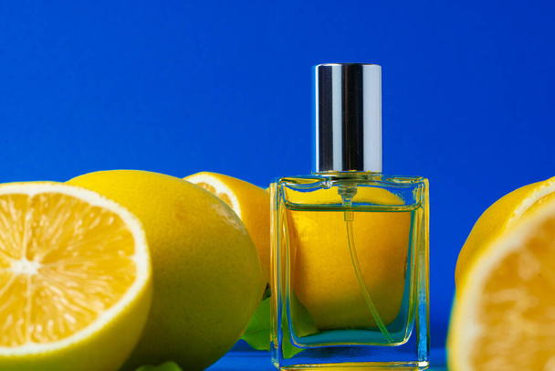 Beautiful composition with bottle of perfume and citrus fruits - Foto, Imagen