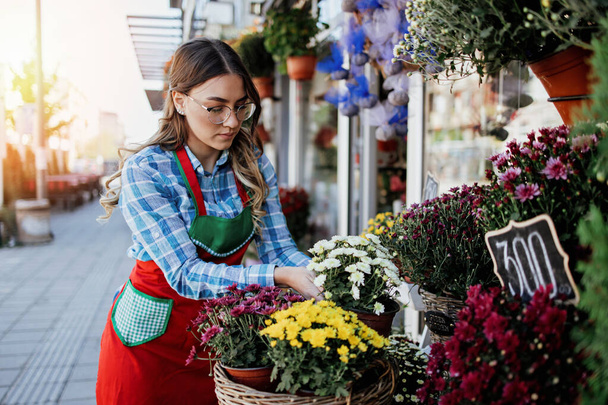 Young adult woman working in city street flower shop or florist. Small business concept. - Foto, immagini