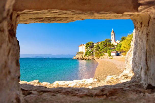 Mosteiro na praia de seixos em Bol vista através de janela de pedra, ilha de Brac, Dalmácia, Croácia - Foto, Imagem