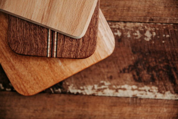 set of wooden cuttng boads on wooden background. Wooden kitchen block close up. - Fotoğraf, Görsel