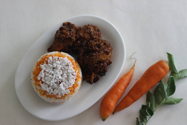 Puttu de zanahoria, una variedad de pastel de vapor de arroz Kerala mediante la adición de zanahorias ralladas servidas junto con asado de pollo preparado en estilo Kerala con aceite de coco y trozos de coco cortados. - Foto, imagen