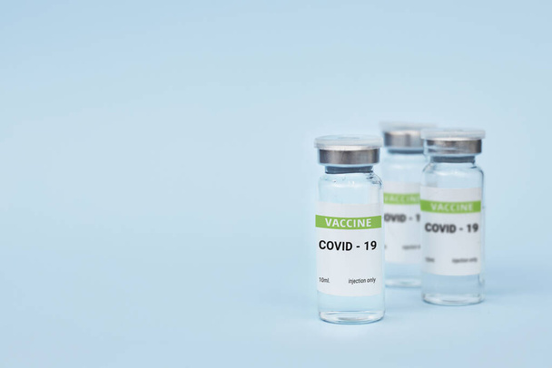 Três latas de vacina contra o coronavírus. num fundo azul. espaço de cópia, bandeira - Foto, Imagem