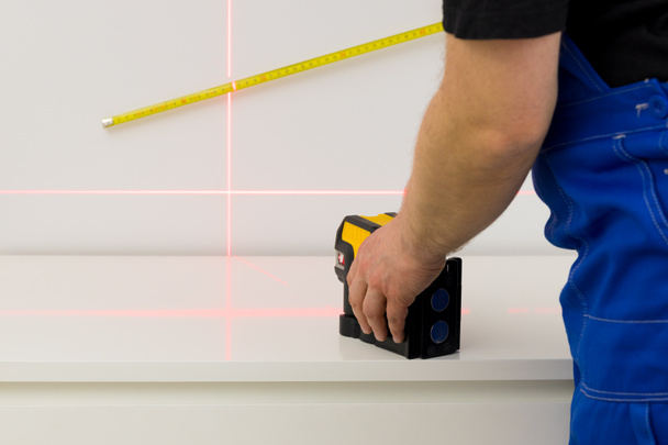 linie na ścianie oznaczone elektronicznym laserem służącym do określania kątów podczas pomiarów konstrukcyjnych i prac wykończeniowych wnętrza  - Zdjęcie, obraz