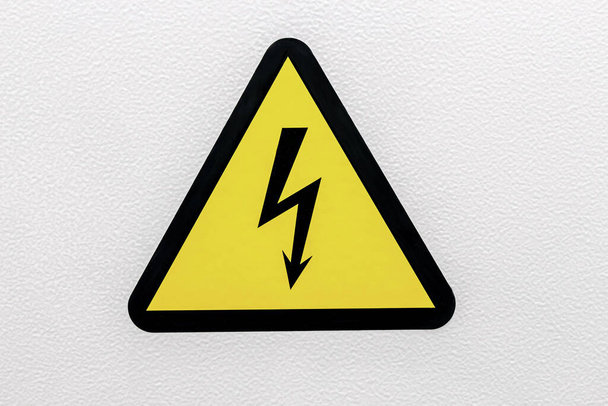 Geel zucht gevaar elektrische schok met bliksem in driehoek op een metalen deur. Gevaar Elektrische Gevaar Hoge Spanning Sign. Sluiten. - Foto, afbeelding