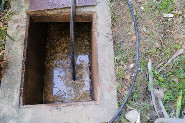 The worker clears the clogged sewer drain using drain clog remover - Photo, Image