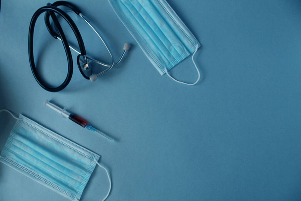 Flatlay medicína pozadí injekční maska stetoskop leží na modrém pozadí s místem pro text s copyspace pohled shora. - Fotografie, Obrázek