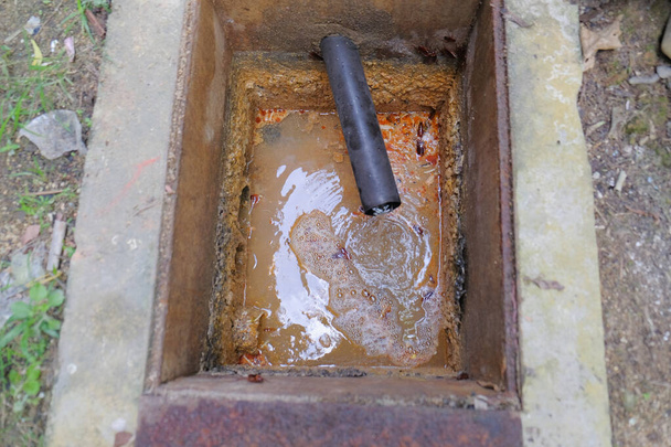 El trabajador limpia el desagüe de la alcantarilla obstruida con un removedor de tapón de desagüe - Foto, imagen