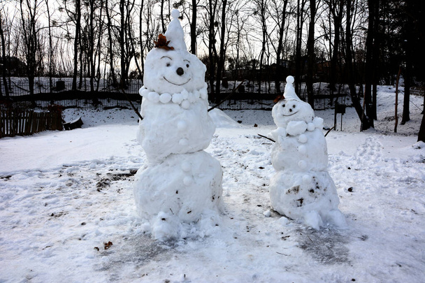Hauska lumiukko tyylikäs hattu ja huivi luminen kenttä. Aamulla ennen joulua. Hassuja lumiukkoja. Lumiukko lahjakassin kanssa. Lumiukko seisoo talvella hattu ja huivi punainen nenä. - Valokuva, kuva