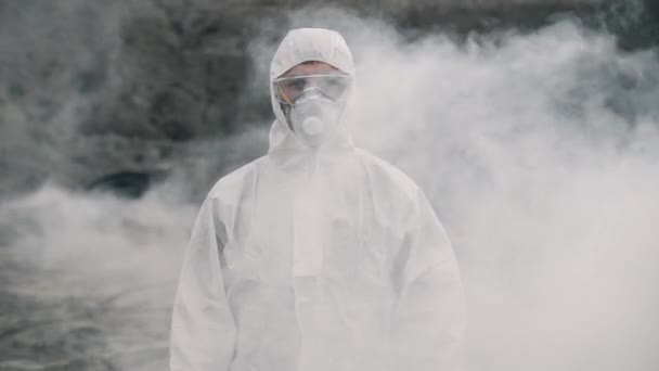 Portrait d'un assistant de laboratoire dans un masque sortant d'une fumée toxique - Séquence, vidéo