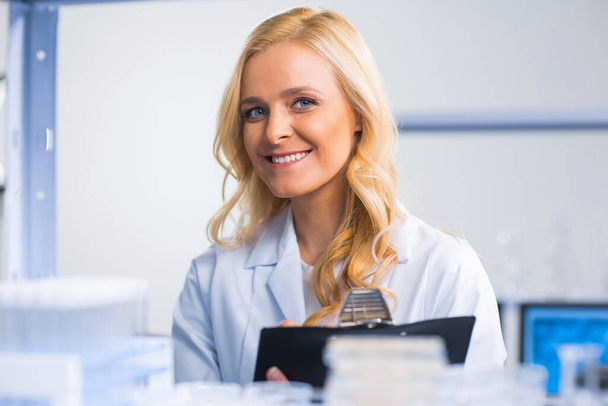 A hivatásos női tudós egy vakcinán dolgozik egy modern tudományos kutató laboratóriumban. Genetikai mérnöki munkahely. Jövőbeli technológia és tudomány. - Fotó, kép