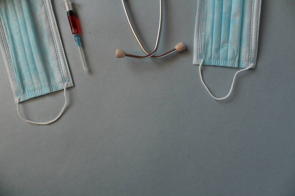 Flatlay médecine fond seringue masque stéthoscope se trouvent sur un fond bleu avec une place pour le texte avec une vue de copyspace d'en haut. - Photo, image