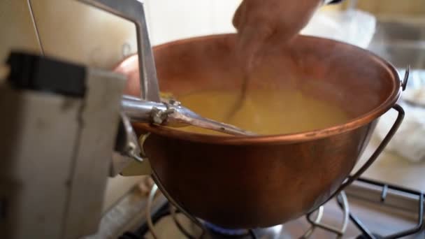 Νόστιμο porriage καλαμπόκι που ονομάζεται πολέντα, πρόσωπο stiriing αργά porriage με ξύλινη κουτάλα σε τηγάνι χαλκού στο σπίτι. Παραδοσιακό ιταλικό πιάτο σε ρουστίκ βόρεια μέρη της χώρας, ιταλική πολέντα μαγείρεμα - Πλάνα, βίντεο