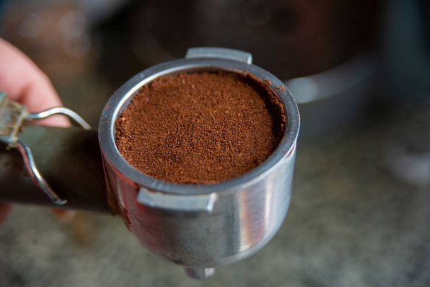 An espresso machine with grounded coffee in hands - 写真・画像