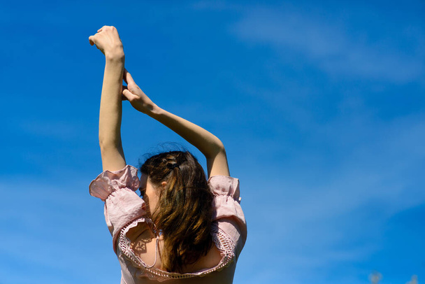 Mutluluk mutluluk özgürlük konsepti. Yaz tatili seyahatleri sırasında kolları havada dans eden mutlu bir kadın. Güzel, genç, neşeli model. - Fotoğraf, Görsel