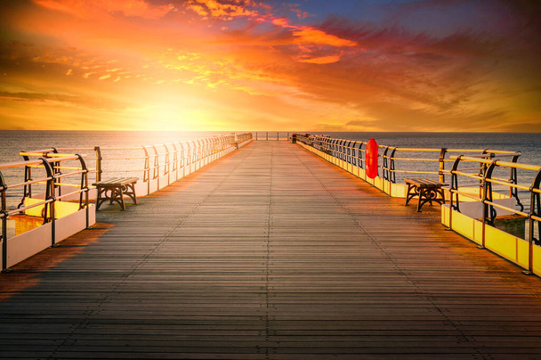 イギリス、ノースヨークシャー、ソルトバーンの日没時の木製の桟橋 - 写真・画像