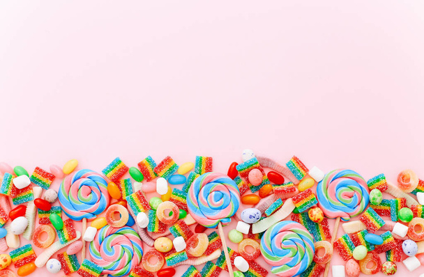 Colección mixta de dulces de colores, sobre fondo rosa. Piso tendido, vista superior - Foto, imagen