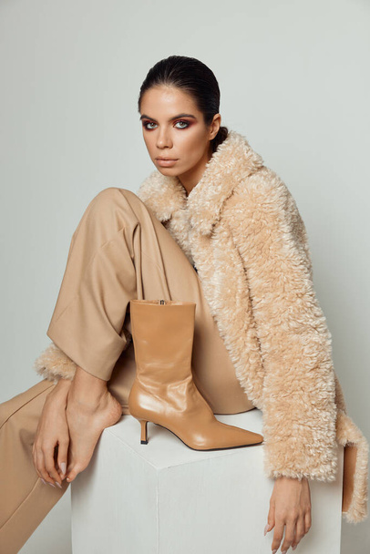 nő divatos bézs kabát mezítláb mellett cipő - Fotó, kép
